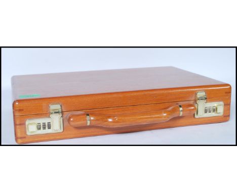 A vintage wooden briefcase having brass code locks to the top, having an upholstered interior with document compartments to t