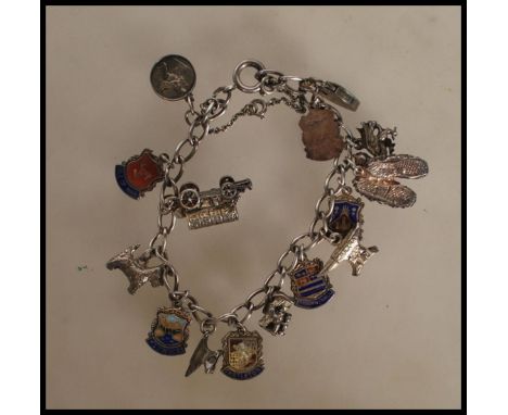 A vintage silver charm bracelet having a curb link chain with a heart padlock having fifteen charms including a dragon, a pai