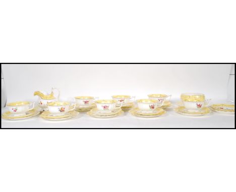 A 20th Century porcelain tea service, each piece decorated with different floral sprays having yellow rims with gilt garland 