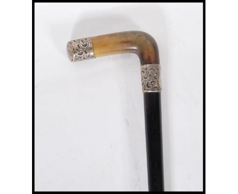 A 19th Century Victorian ebonised walking stick cane having a silver collar and end with engraved decoration on a horn crook 