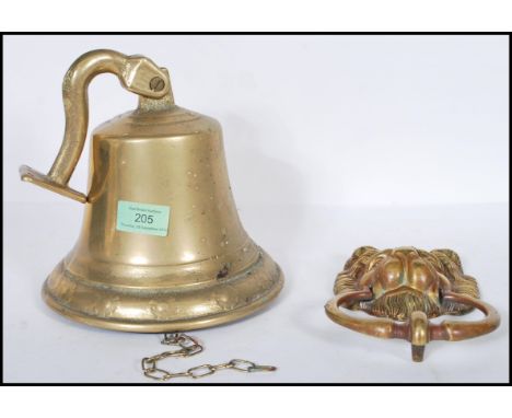 A 20th Century large brass ships style bell with wall hanging bracket attached together with a gilt Victorian style lion mask