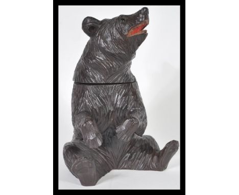 A 20th Century German Black Forest hand carved wooden tobacco pot or tea caddy in the form of a bear having hinged lid to hea