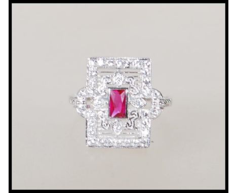 A sterling silver ladies Art Deco style dress ring of rectangular form having a central ruby with cz accent stones throughout