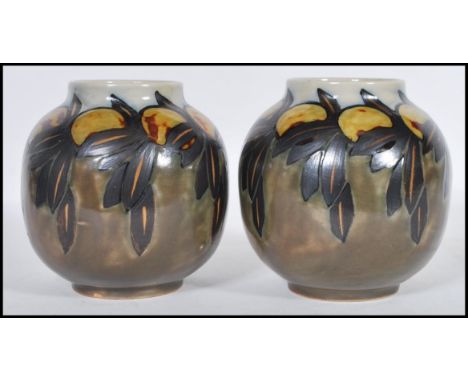 A pair of early 20th Century Royal Doulton ceramic vases of globular form having hand painted decoration of Lemons. Impressed