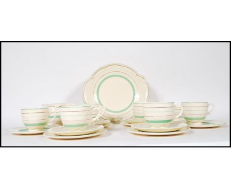 A 1920's Art Deco Clarice Cliff for Newport tea service having a cream ground with painted green and gilt stripes consisting 