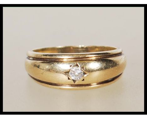 A stamped 375 9ct gold ring gypsy set with a round cut diamond. Weight 4.7g. Diamond estimated at 7pts. Size P.