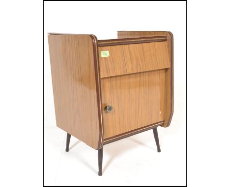 A vintage mid 20th century retro vintage wood grained formica bedside cabinet having a single short drawer above a cupboard a