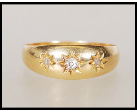A hallmarked 18ct gold gypsy ring set with three round cut diamonds. Hallmarked Chester 1913. Weight 2.9g. Size Q.