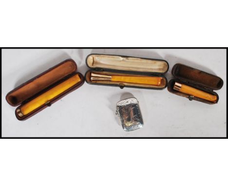 A group of three leather cased butterscotch amber bakelite cheroot holders dating from the early 20th Century with all three 