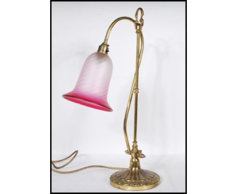 A vintage mid 20th Century swan neck desk lamp raised on a stepped round base with gadrooned and scrolled repousse decoration