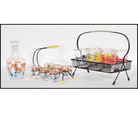 A set of six retro mid 20th Century shot glasses with retro 1960's decoration to the glass bodys with gilt rims held within a