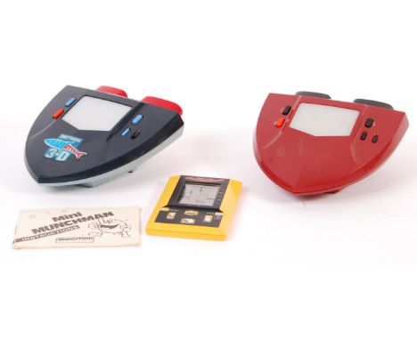 A collection of three vintage electronic handheld games to include a Grandstand Mini Munchman with instructions, Tomy Shark A