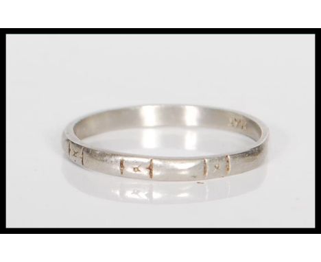 A stamped platinum band ring having engraved geometric decoration. Weight 2.4g. Size M.5.