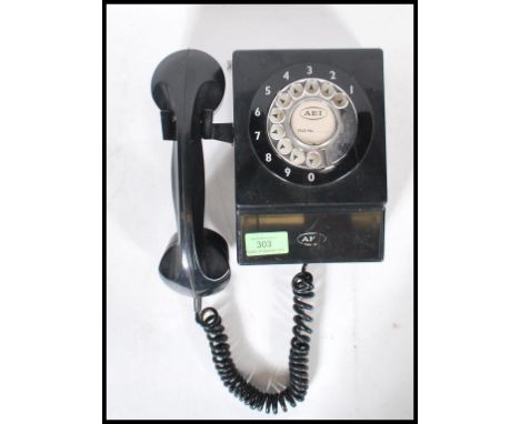 A vintage retro mid 20th Century wall hanging telephone having a black bakelite body with a chromed rotary dial.&nbsp;