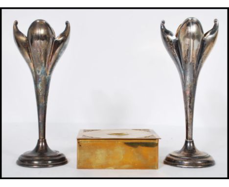 A pair of silver plated Art Nouveau mantelpiece spill vases in the form of opening flowers raised on round stepped pedestal b