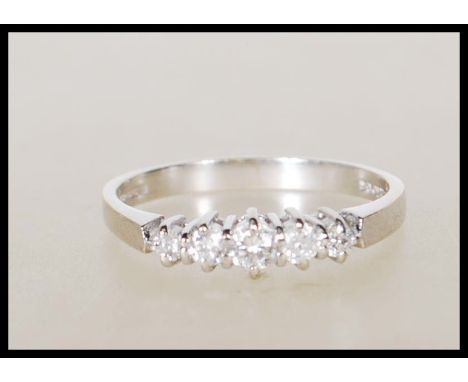 A hallmarked 18ct white gold&nbsp;ladies dress ring set with five graduating diamonds of approx 25 points. Hallmarked 750 and