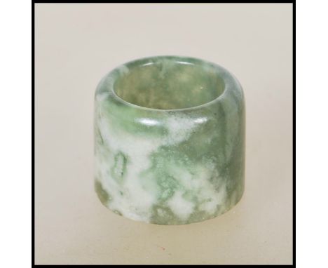 A 20th Century Chinese large mottled dark green and red jade archer's thumb ring of cylindrical form. Measures 3 cm tall by 3