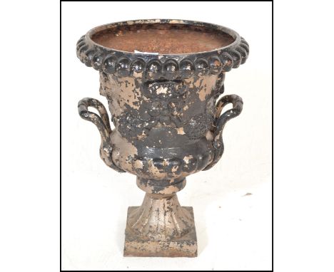 A 19th Century Victorian cast metal Campana urn planter having twin handles with raised lions mask decoration and floral garl