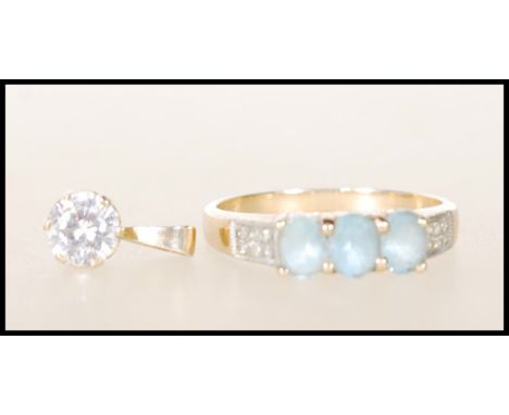 A hallmarked 9ct gold ladies dress ring set with three light blue stones with white accent stones to the shoulders, together 