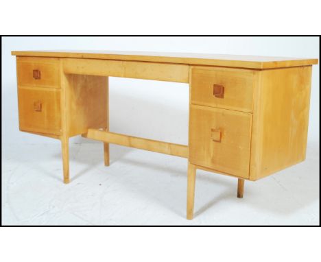 A vintage mis 20th Century beech kneehole writing desk of concave form, having a configuration of five drawers fitted with sq