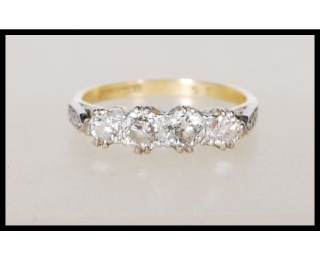 An 18ct yellow gold ring set with four diamonds having platinum shoulders having illusion set diamonds. Approx 75pts. Ring si