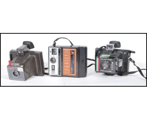 A collection of three original vintage retro polaroid instant cameras / land camera comprising: A boxed Polaroid Super Swinge
