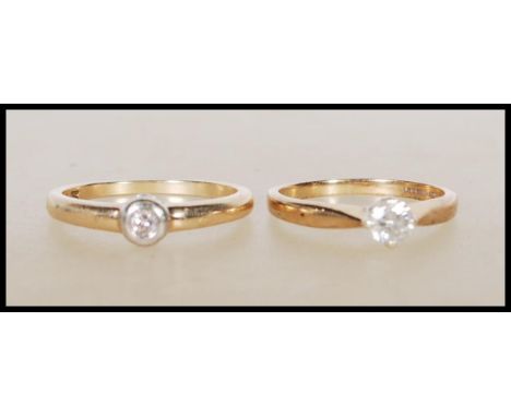 Two hallmarked 9ct yellow gold single stone solitaire diamond rings. One ring having a prong set diamond of approx 30pts, hal