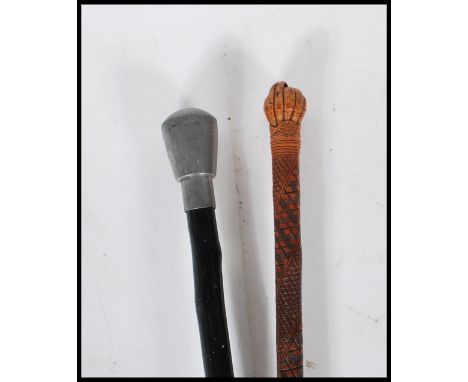 A 20th Century malacca walking stick having engraved geometric decoration to the shaft with a carved nut to the top along wit