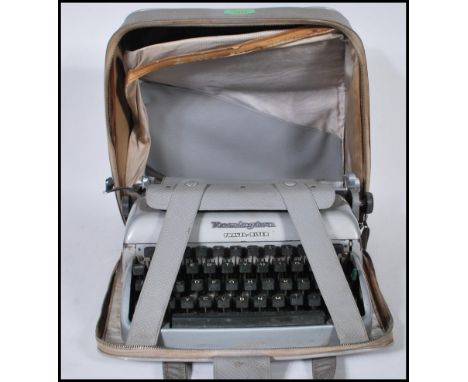 A mid 20th Century vintage Remington Travel-Riter portable typewriter having a grey enamel finish complete in carry case.