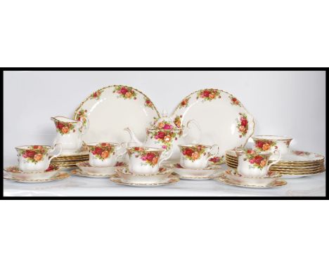 A Royal Albert bone China dinner / tea service in the Country Roses pattern. Consisting of dinner plates, side plates, cups a