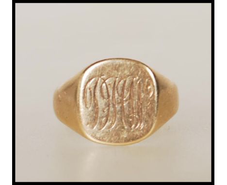 A 9ct gold signet ring having a cushion shaped panel head engraved with with initials. Assay marks for Birmingham. Weight 6.4