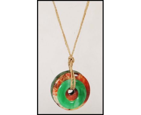 Two Chinese round jade pendants together with a round soapstone pendant held together with a rope necklace. Largest pendant m