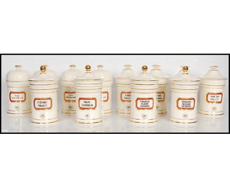A group of twelve 20th Century Chalsyn Ltd ceramic apothecary jars and covers all having white grounds with raised rectangula