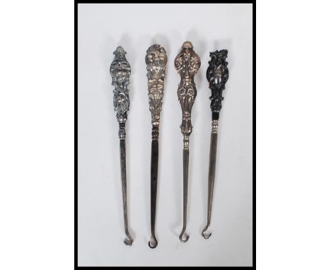 A group of three early 20th Century silver hallmarked button hooks. Each one having a silver embossed floral and swirl decora