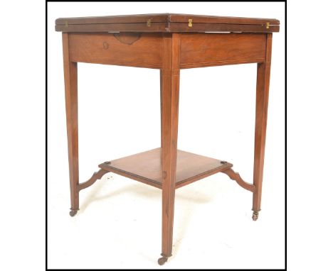 An early 20th Century Edwardian mahogany envelope card table, the top&nbsp;swivelling round to reveal well and opening out to