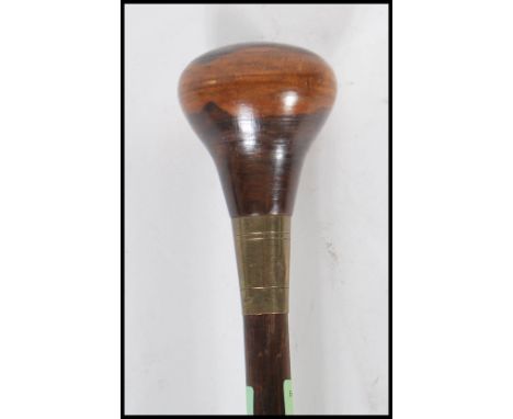 An early 20th Century walking stick cane having a white metal collar and a turned wooden knop.&nbsp;