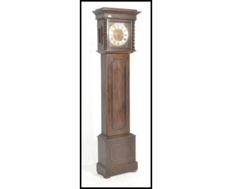 A 20th Century panel oak cased grandmother clock. The trunk with geometric carved embellishments, the brass face with barley 