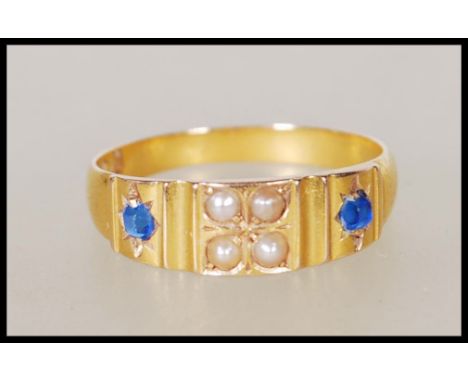 A hallmarked 15ct gold ring set with four seed pearls flanked by two gypsy set sapphires. Hallmarked Birmingham 1882. Weight 