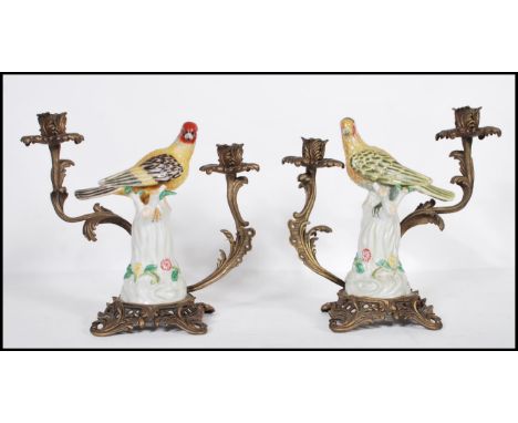 A pair of 20th Century Continental barss and the ceramic candlesticks. The centers having ceramic birds raised on a white pai