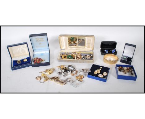 A collection of vintage costume jewellery to include a selection of gold plated cufflinks, a faux malachite celtic style broo