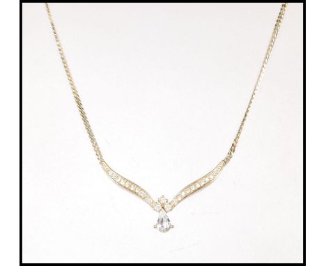 A vintage gold plated Christian Dior necklace having a V shaped collar terminating in a drop shaped white stone with further 