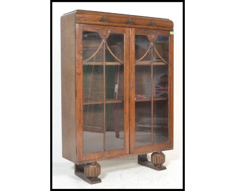 A first half of the 20th Century oak twin glazed door china display cabinet adjustable shelves to the interior raised on reed