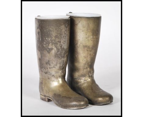 A pair of original vintage 20th Century silver plated novelty drinks measures in the form of riding boots having white bakeli