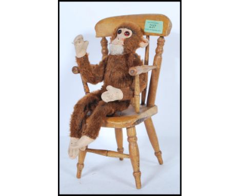 A vintage 1950's Merrythought made soft toy straw filled monkey with bead eyes and original label along with a small wooden W