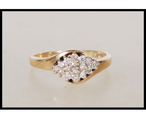 A 9ct gold English hallmarked diamond cluster ring with a crossover design. Hallmarked Sheffield 1993. Weight 2.5g. Size M.