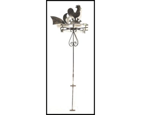 A early 20th Century cast iron weather vane having scroll work to body with&nbsp;cockerel, moon and sun motif to top over the