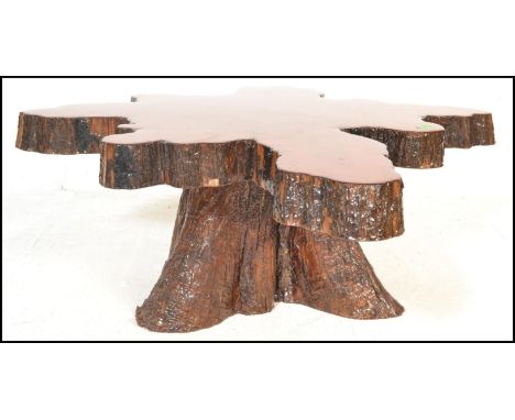 A vintage 20th Century live edge Cypress wood coffee table constructed from a cross section of a tree being heavily lacquered