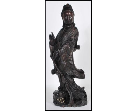 An early 20th Century Chinese carved figurine of&nbsp; female immortal figure holding one hand aloft standing above a crouche