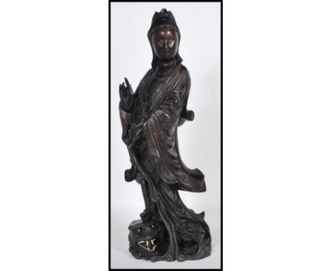 An early 20th Century Chinese carved figurine of&nbsp; female immortal figure holding one hand aloft standing above a crouche