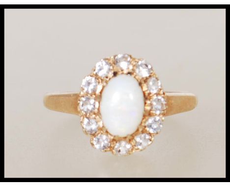 A hallmarked 9ct gold ring set with a central oval cabochon with a halo of white stones. Hallmarked Birmingham 1987. Weight 2